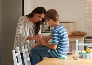 woman caring for sons wound