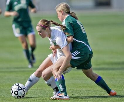 two girls playing soccer